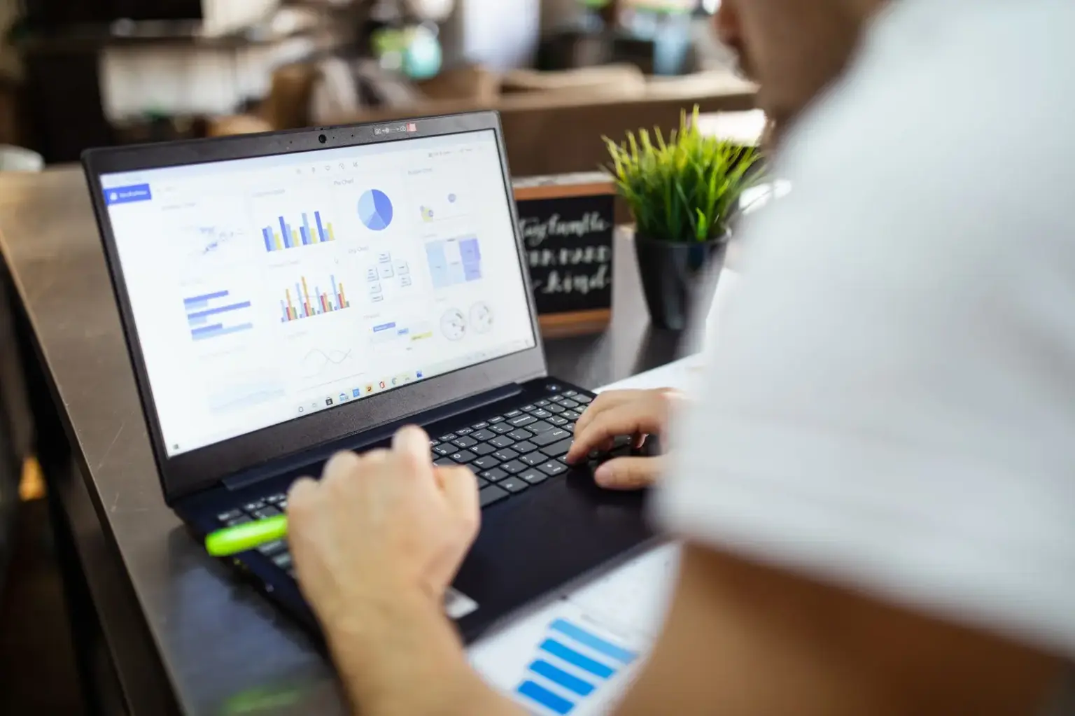 Junger Erwachsener analysiert Diagramme auf einem Laptop