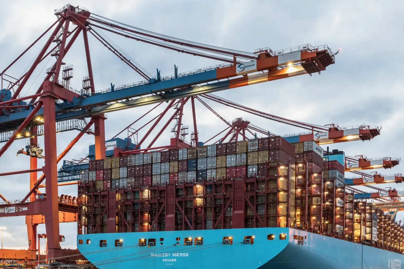 Beladenes Containerschiff unter Hafenkränen im Hamburger Hafen