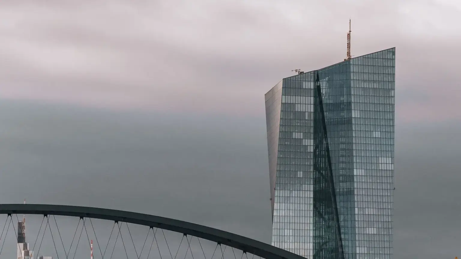 Hochhaus der Europäischen Zentralbank in Frankfurt hinter einer Brücke