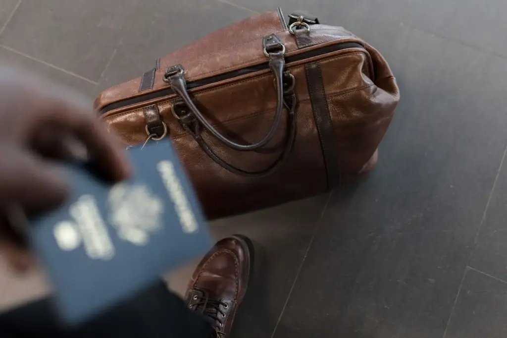 Braune Reisetasche und Reisepass in einem Flughafenterminal