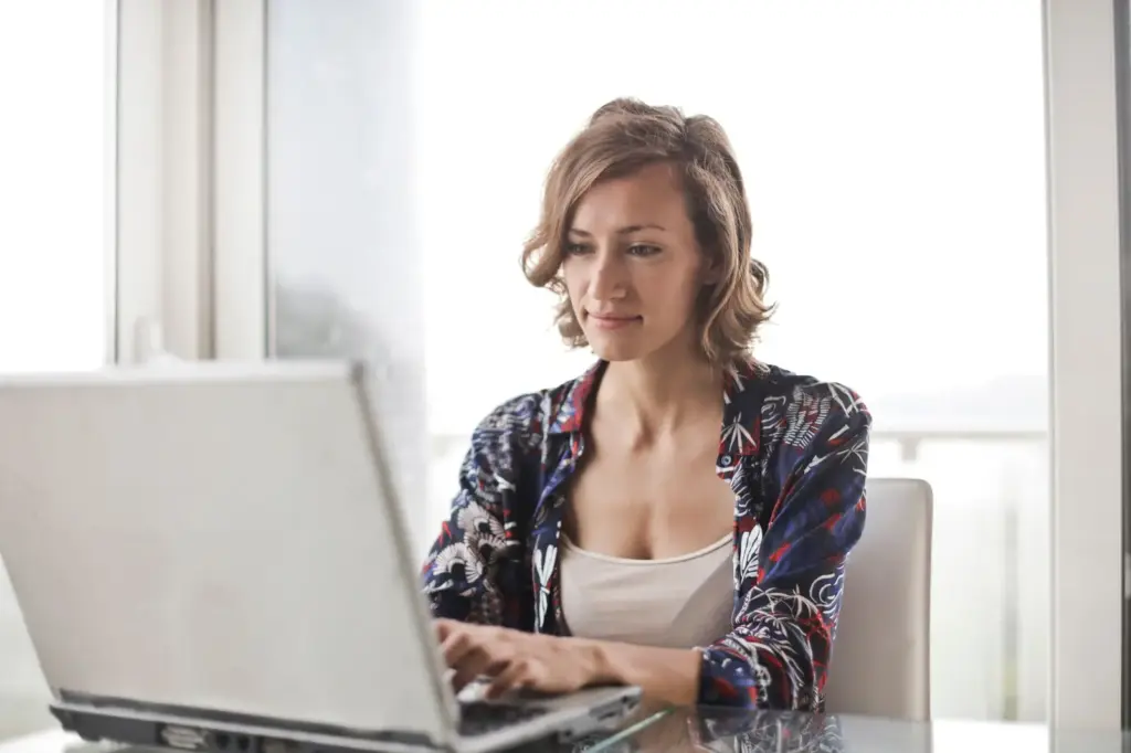 Frau arbeitet an einem Laptop in einem hellen Homeoffice