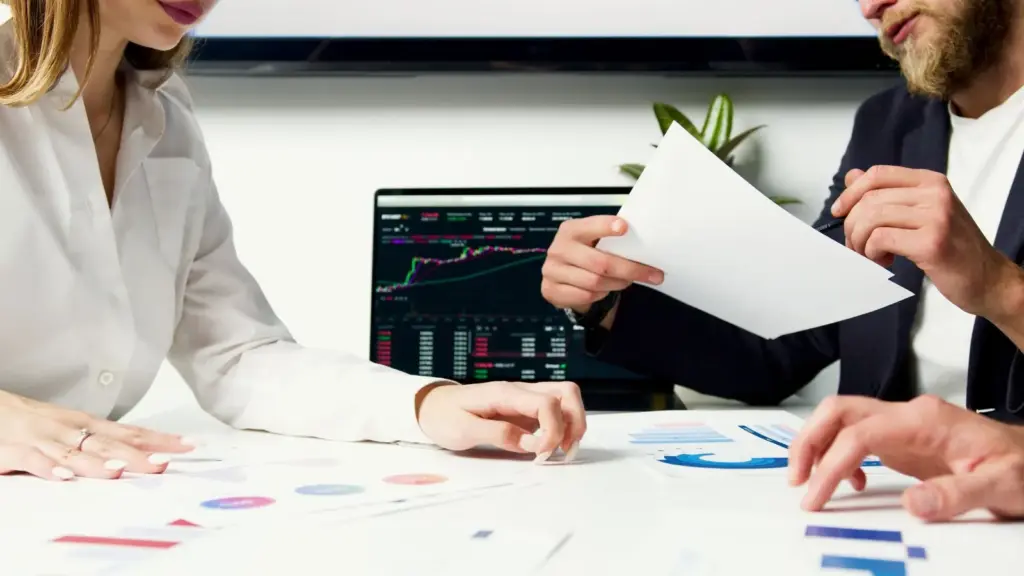 Gründungsteam prüft Finanzunterlagen und Diagramme an einem Besprechungstisch