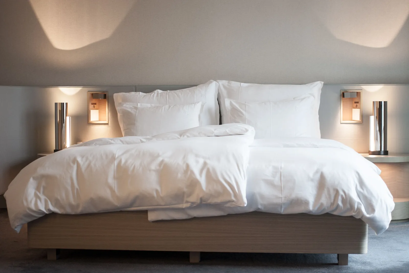 Helles Hotelzimmer in Deutschland mit weiß bezogenem Doppelbett