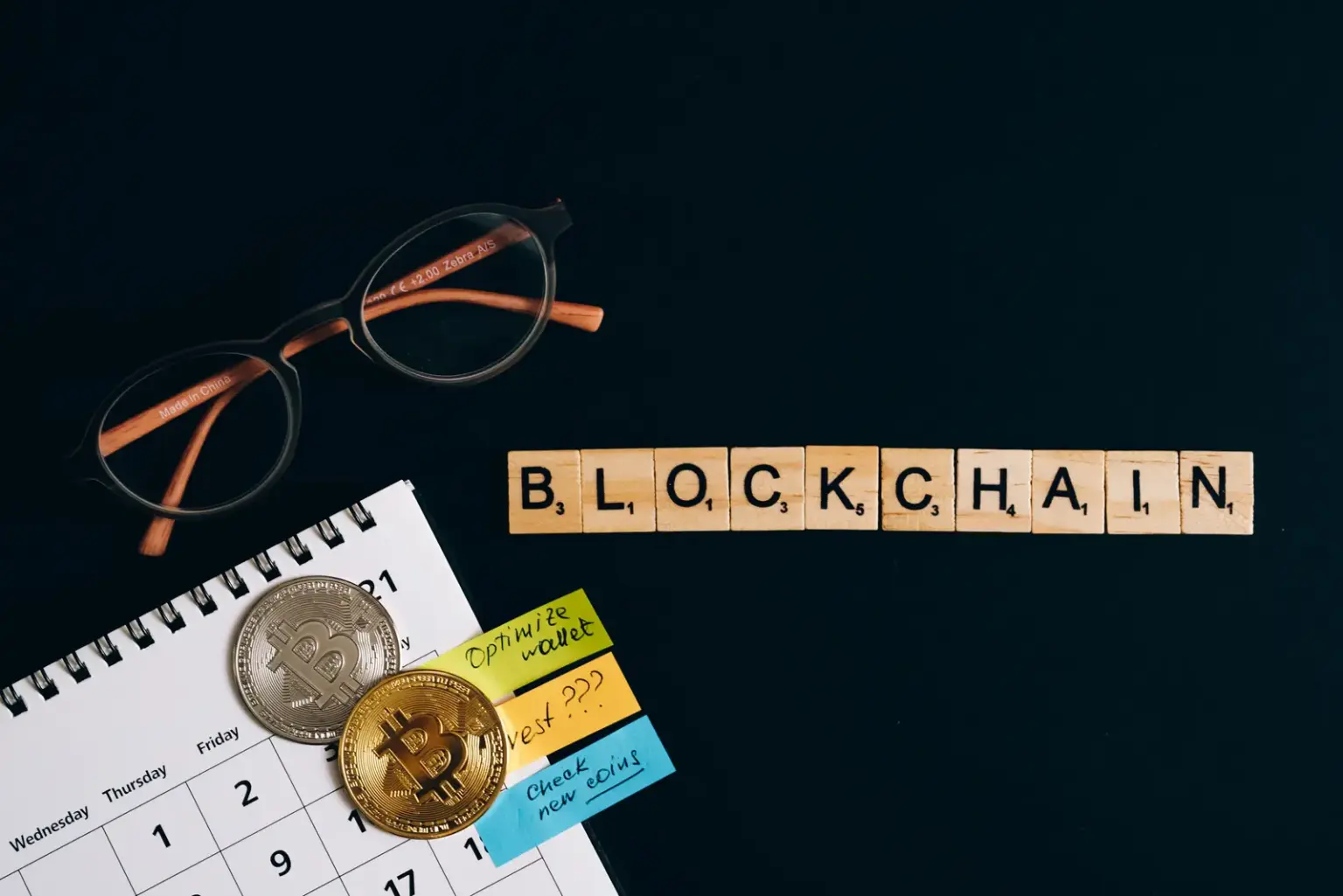 Schriftzug Blockchain mit Bitcoin-Münzen und Finanzunterlagen