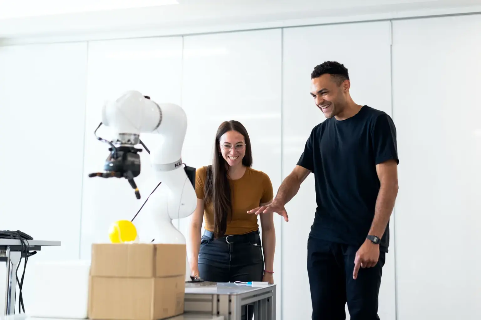Zwei Ingenieure testen einen Robotik-Prototyp in einem hellen Entwicklungslabor
