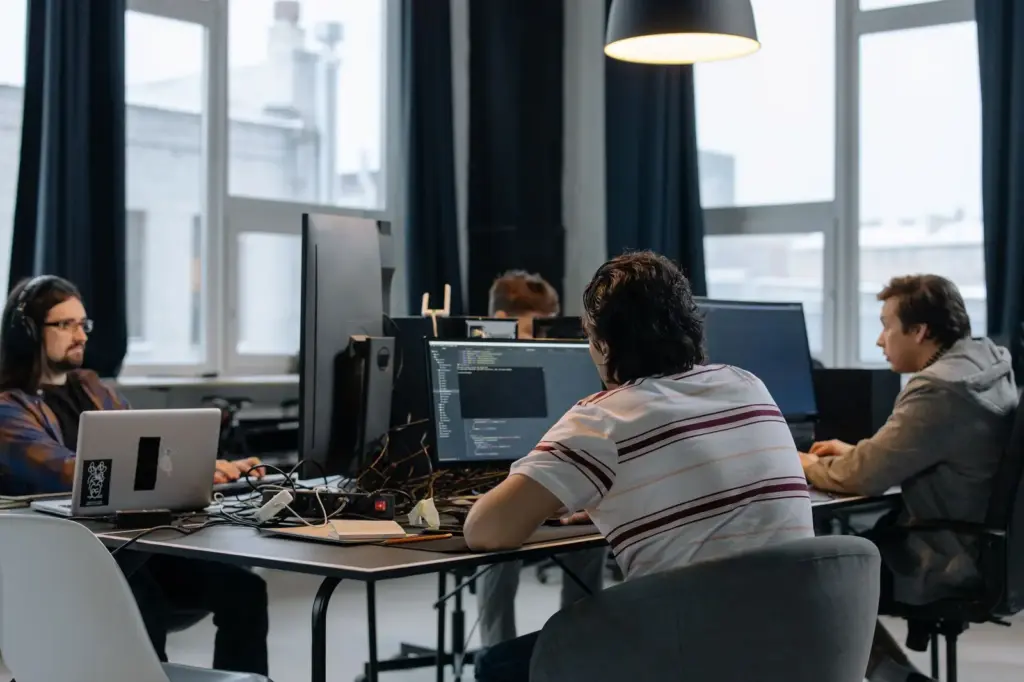 Softwareentwickler arbeiten gemeinsam an Computern in einem modernen Start-up-Büro