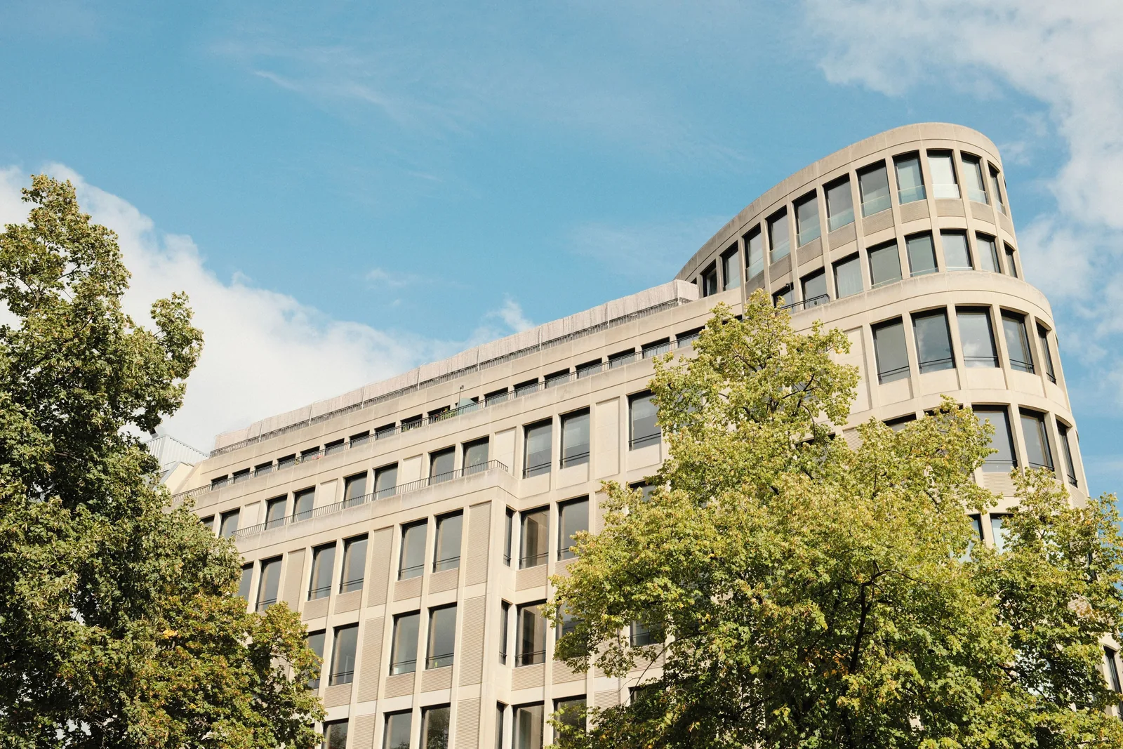 Modernes Bürogebäude mit Bäumen unter blauem Himmel in Berlin