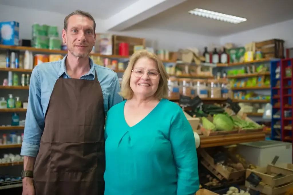 Zwei Inhaber stehen gemeinsam in einem kleinen Lebensmittelgeschäft