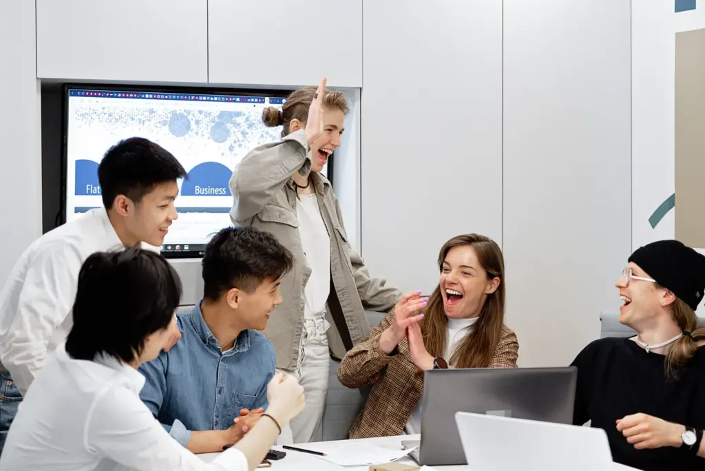 Kolleginnen und Kollegen feiern gemeinsam einen Erfolg in einem modernen Büro