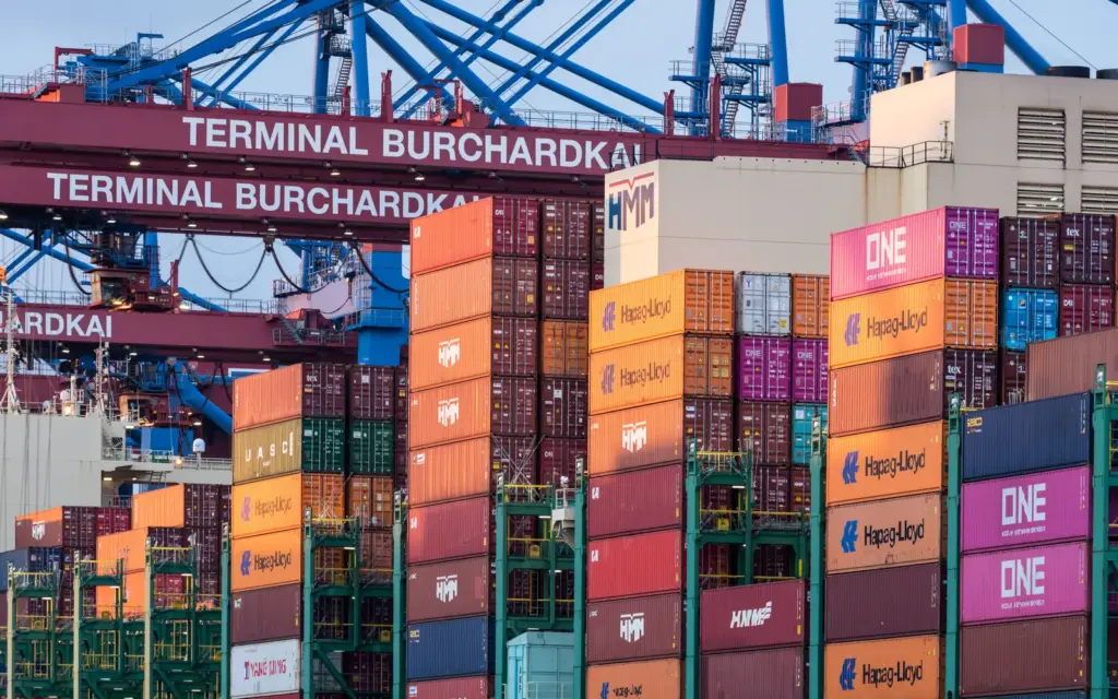 Gestapelte Frachtcontainer und Hafenkräne am Terminal Burchardkai in Hamburg