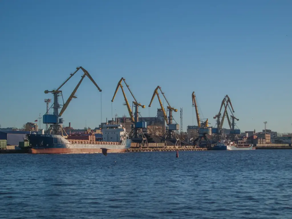 Schiffe liegen zwischen großen Industriekränen in einer Werft