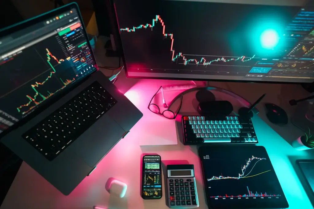 Arbeitsplatz mit mehreren Bildschirmen und digitalen Finanzmarkt-Charts