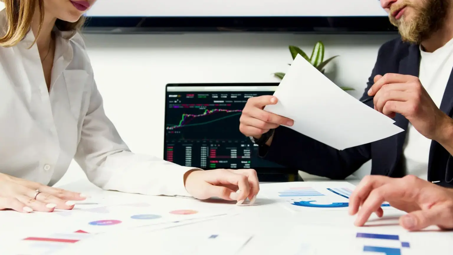 Gründungsteam prüft Finanzunterlagen und Diagramme an einem Besprechungstisch