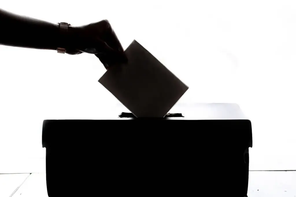 Stimmzettel wird in eine Wahlurne eingeworfen