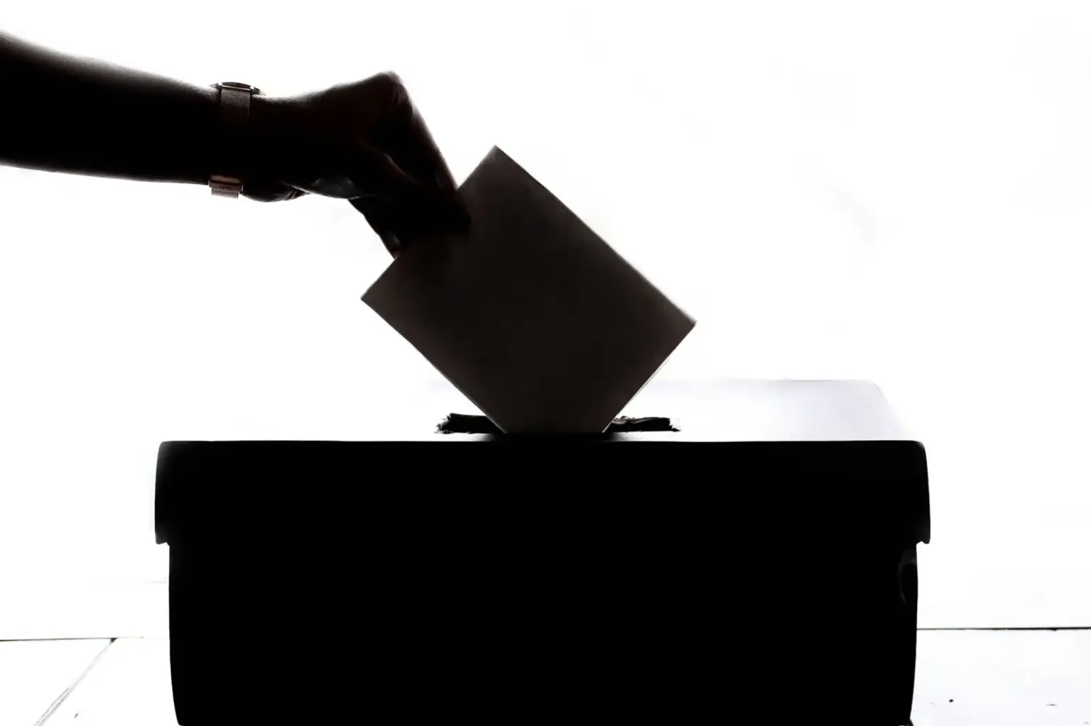 Stimmzettel wird in eine Wahlurne eingeworfen