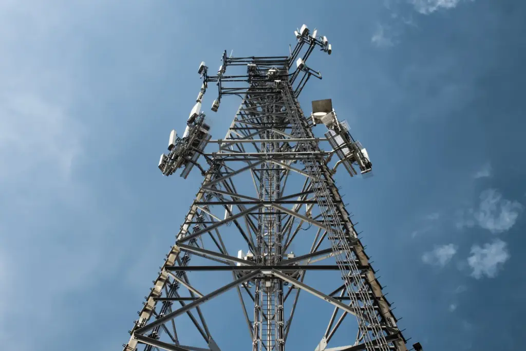 Mobilfunkmast mit Antennen vor blauem Himmel