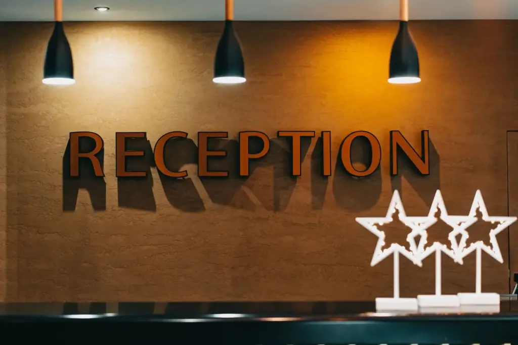 Beleuchteter Schriftzug Reception an der Empfangstheke eines Hotels
