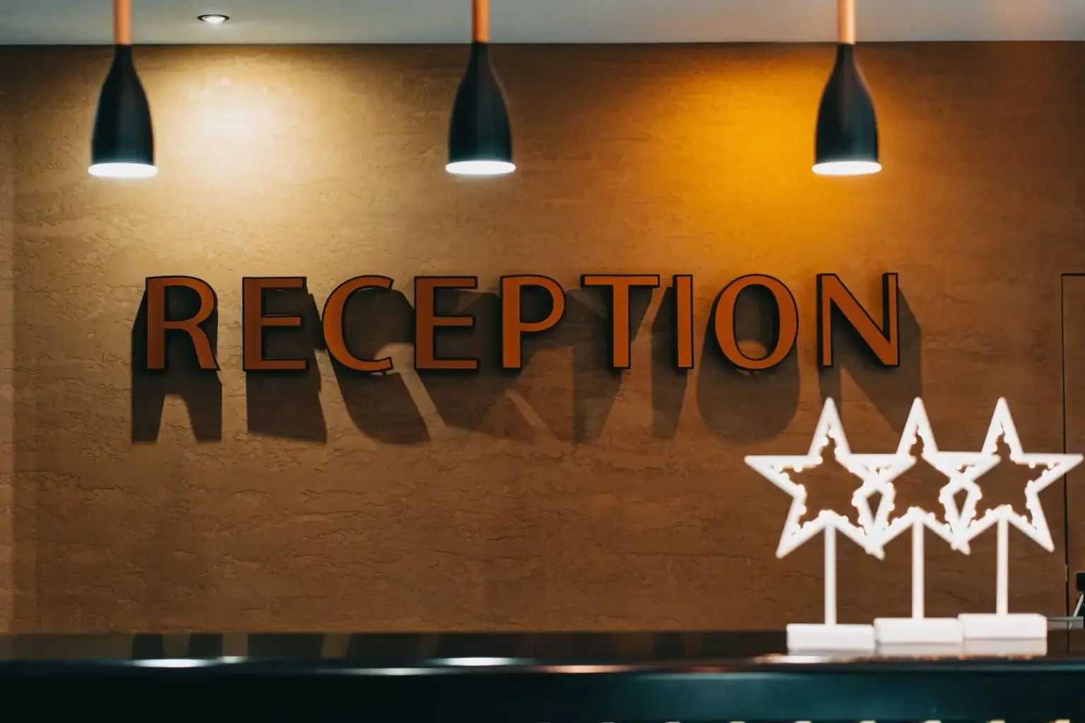 Beleuchteter Schriftzug Reception an der Empfangstheke eines Hotels