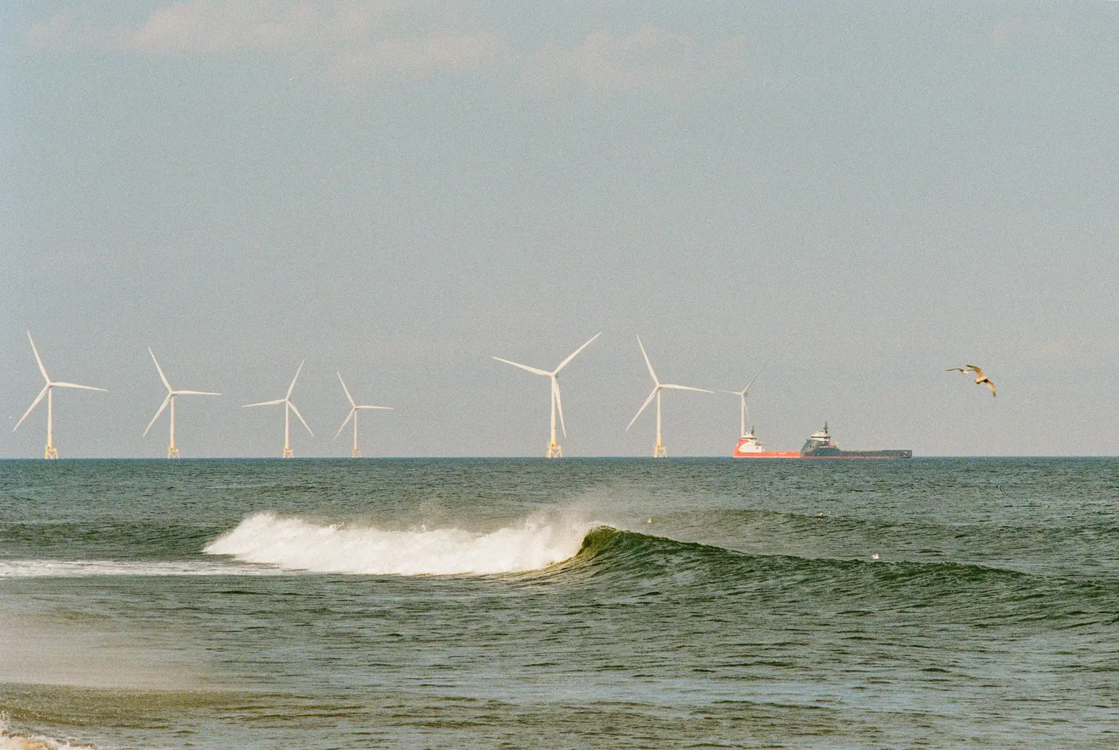 Offshore-Windkraftanlagen in der Nordsee mit Frachtschiff im Hintergrund