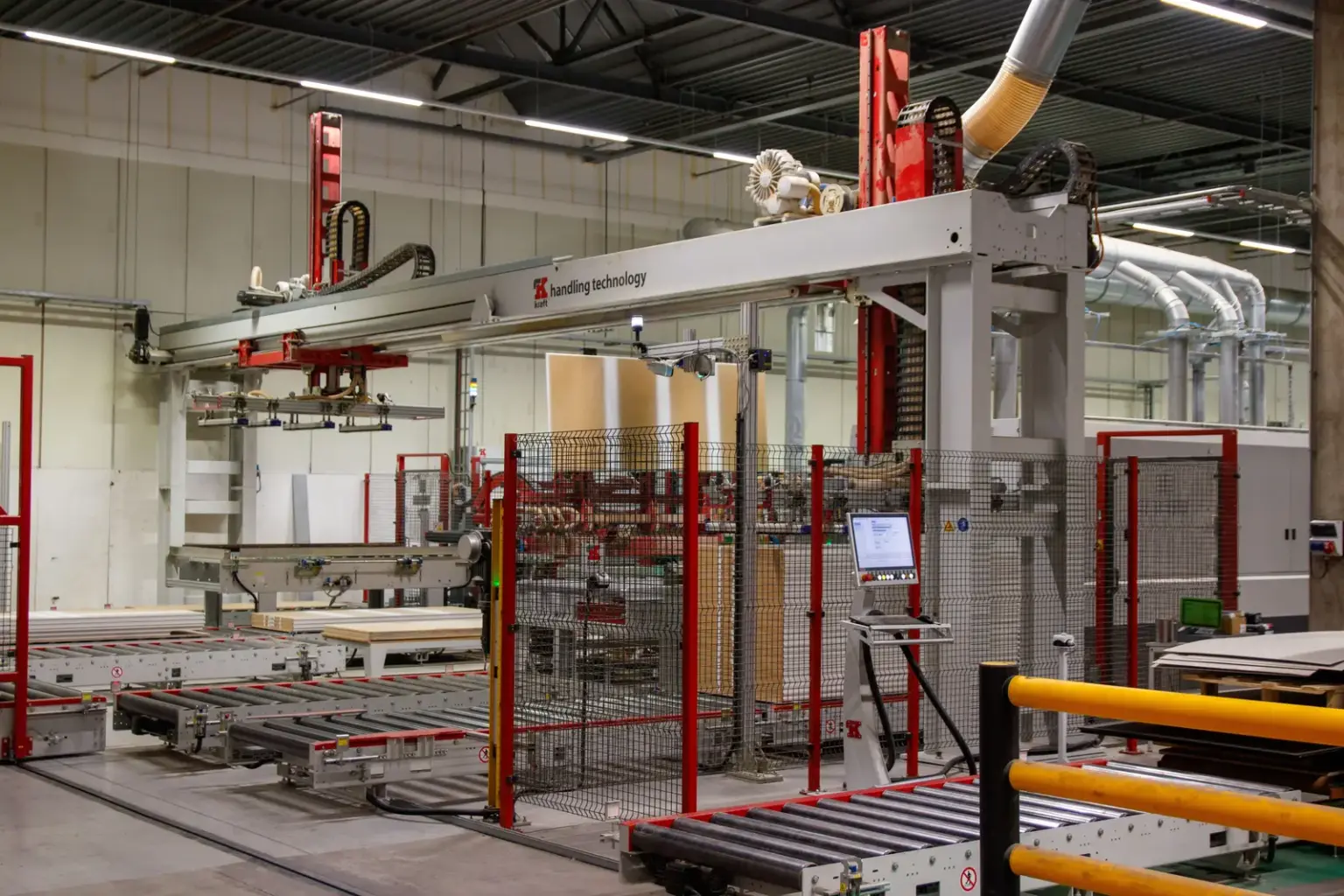 Automatisierte Fertigungsanlage mit Förderbändern und Greiftechnik in einer modernen Fabrikhalle