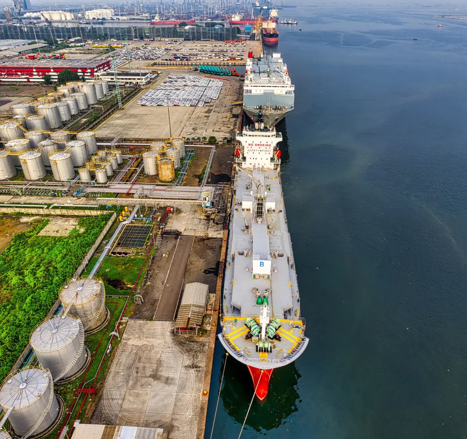 Öltanker liegt an einem Terminal mit industriellen Lagertanks